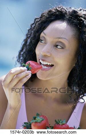 Close-up of a young woman eating strawberries View Large Photo Image Stock Image - Close-up of a young woman eating strawberries. Fotosearch