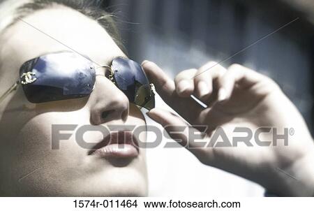 Close-up of a young woman wearing sunglasses View Large Photo Image Picture - Close-up of a young woman wearing sunglasses. Fotosearch