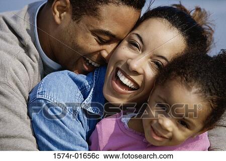 Close-up of parents hugging their daughter View Large Photo Image Stock Image - Close-up of parents hugging their daughter. Fotosearch