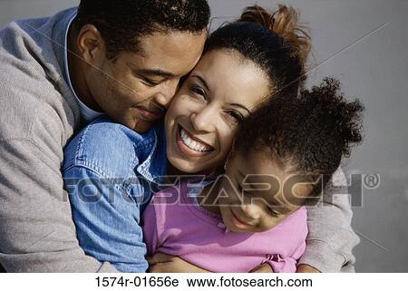 Close-up of parents hugging their daughter View Large Photo Image Stock Image - Close-up of parents hugging their daughter. Fotosearch