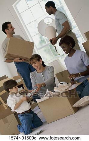 Stock Image - Family unpacking boxes in a house. Fotosearch