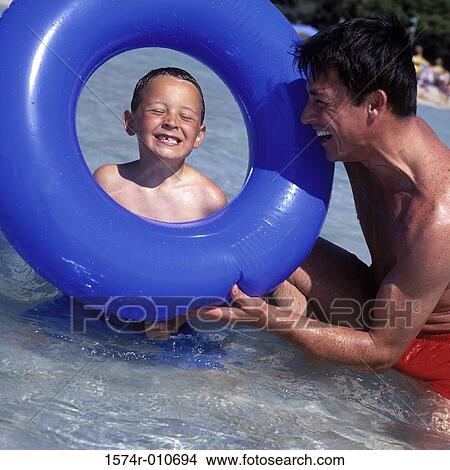 Father and his son playing in the water at the beach View Large Photo Image Picture - Father and his son playing in the water at the beach. Fotosearch