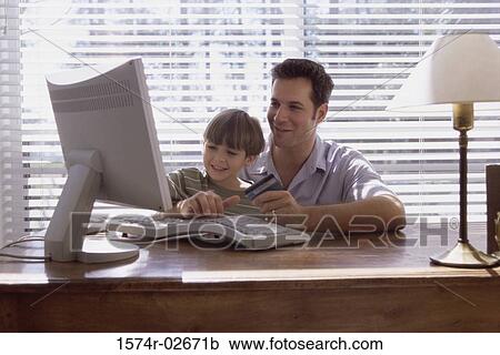 Father and his son sitting in front of a computer View Large Photo Image Stock Image - Father and his son sitting in front of a computer. Fotosearch