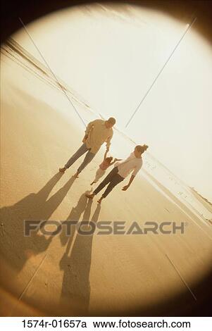 Stock Image - Father and mother with their daughter at the beach. Fotosearch