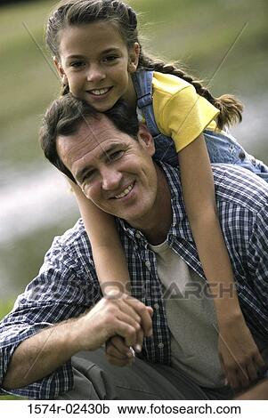 Father carrying his daughter on his back View Large Photo Image Stock Image - Father carrying his daughter on his back. Fotosearch