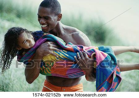 Father carrying his daughter on the beach View Large Photo Image Stock Image - Father carrying his daughter on the beach. Fotosearch