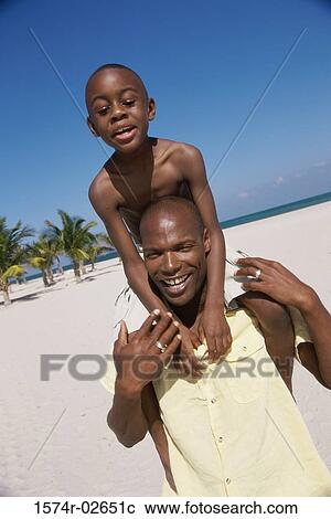 Father carrying his son on his shoulder View Large Photo Image Stock Image - Father carrying his son on his shoulder. Fotosearch