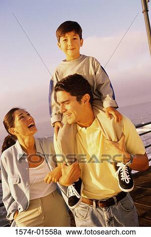 Stock Image - Father carrying his son on his shoulders. Fotosearch
