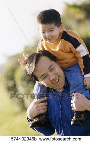 Father carrying his son on his shoulders View Large Photo Image Stock Image - Father carrying his son on his shoulders. Fotosearch