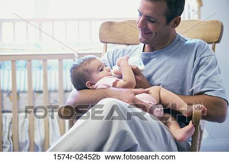 Stock Image - Father feeding his baby boy. Fotosearch