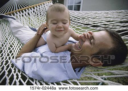 Father lying in a hammock with his baby boy View Large Photo Image Stock Image - Father lying in a hammock with his baby boy. Fotosearch