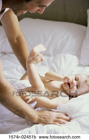 Stock Image - Father playing with his baby boy. Fotosearch