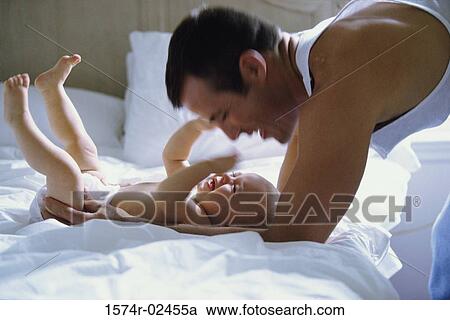 Stock Image - Father playing with his baby boy. Fotosearch