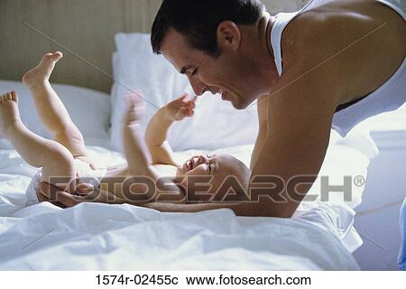 Stock Image - Father playing with his baby boy. Fotosearch