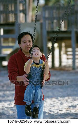 Father pushing his son on a swing View Large Photo Image Stock Image - Father pushing his son on a swing. Fotosearch
