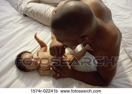 Stock Image - Father tickling his baby boy. Fotosearch