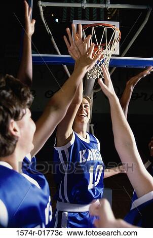 Stock Image - Female basketball players reaching upwards. Fotosearch