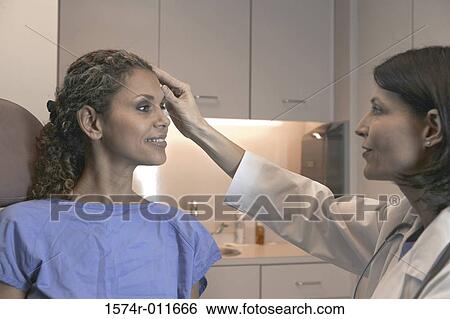 Stock Photograph - Female doctor examining a female patient. Fotosearch