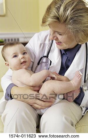 Female doctor holding a baby boy View Large Photo Image Stock Image - Female doctor holding a baby boy. Fotosearch