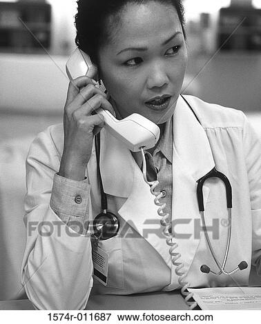 Stock Photo - Female doctor talking on a telephone. Fotosearch