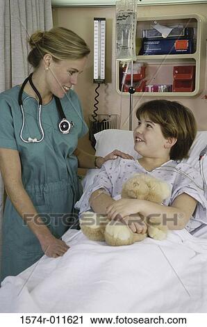 Female doctor talking to a girl lying in bed View Large Photo Image Stock Image - Female doctor talking to a girl lying in bed. Fotosearch