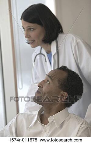 Female doctor with a male patient View Large Photo Image Stock Photo - Female doctor with a male patient. Fotosearch