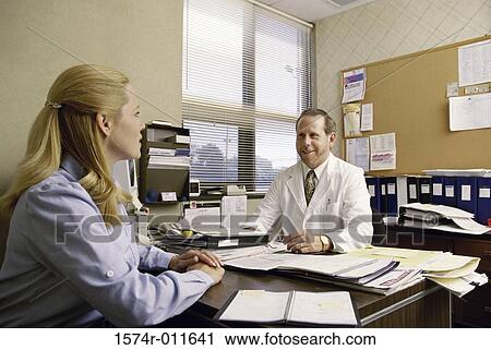 Female patient consulting a male doctor View Large Photo Image Stock Image - Female patient consulting a male doctor. Fotosearch