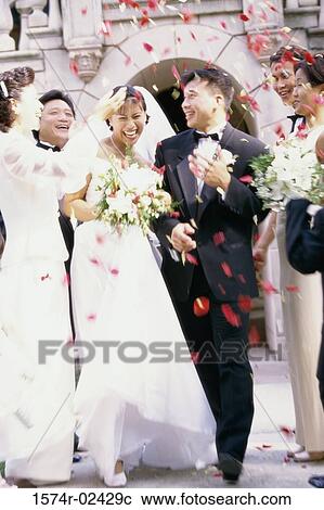 Flower petals being thrown on a bride and groom View Large Photo Image Stock Image - Flower petals being thrown on a bride and groom. Fotosearch