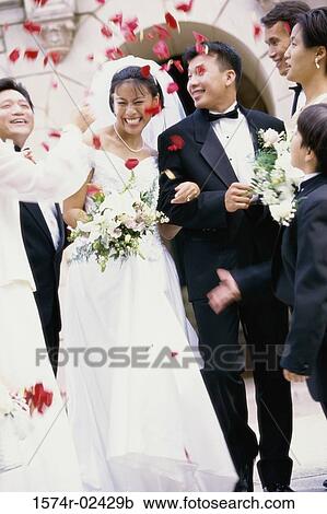 Stock Image - Flower petals thrown on a newlywed couple. Fotosearch