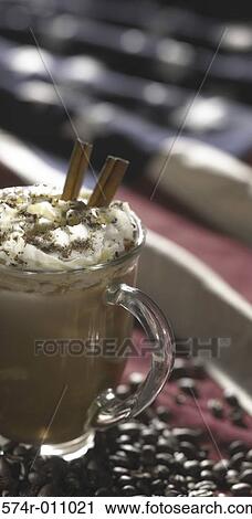 Stock Image - Glass of cold coffee and cinnamon sticks. Fotosearch