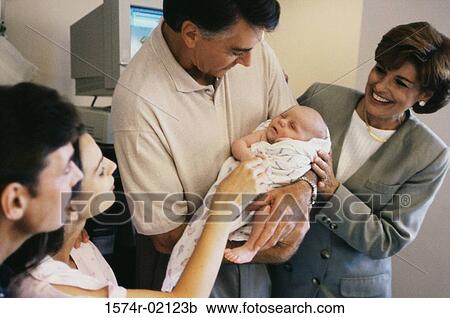 Stock Image - Grandparents carrying their baby boy in the hospital. Fotosearch
