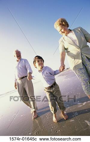 Grandson running at the beach with his grandparents View Large Photo Image Stock Image - Grandson running at the beach with his grandparents. Fotosearch