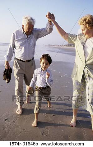 Grandson running at the beach with his grandparents View Large Photo Image Stock Image - Grandson running at the beach with his grandparents. Fotosearch