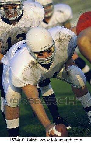 Stock Image - Group of men playing American football. Fotosearch