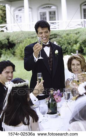 Stock Image - Group of people at a wedding toasting with glasses of champagne. Fotosearch