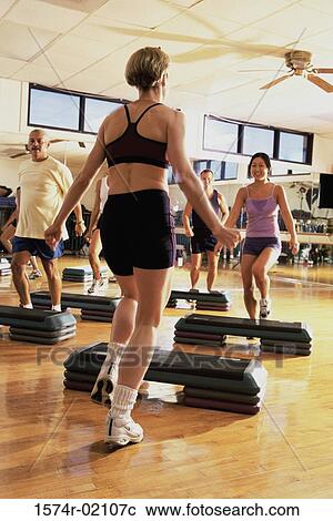 Stock Image - Group of people exercising in a step aerobics class. Fotosearch