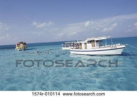 Group of people swimming in the sea near a boat View Large Photo Image Picture - Group of people swimming in the sea near a boat. Fotosearch