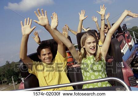 Stock Image - Group of teenagers riding a rollercoaster. Fotosearch