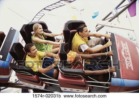 Stock Image - Group of teenagers riding a rollercoaster. Fotosearch