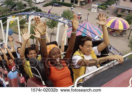 Stock Image - Group of teenagers riding a rollercoaster. Fotosearch