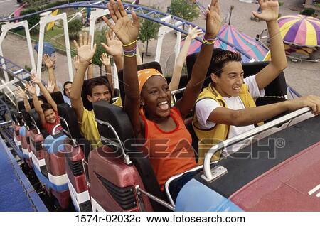 Stock Image - Group of teenagers riding a rollercoaster. Fotosearch