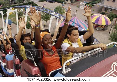 Stock Image - Group of teenagers riding a rollercoaster. Fotosearch
