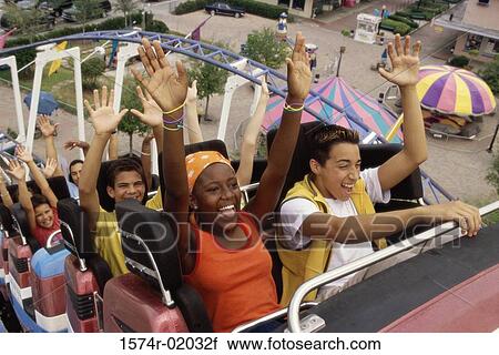 Stock Image - Group of teenagers riding a rollercoaster. Fotosearch