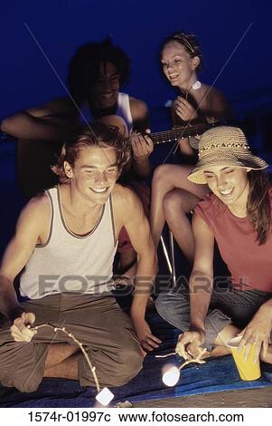Group of young people having a barbecue on the beach View Large Photo Image Stock Image - Group of young people having a barbecue on the beach. Fotosearch