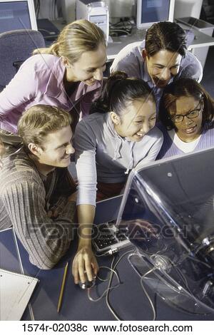Stock Image - Group of young people in front of a computer monitor. Fotosearch