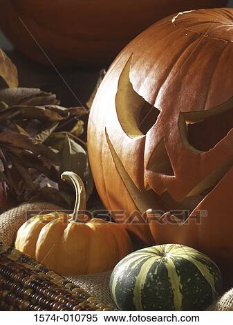 Stock Photography - Halloween jack-o'-lantern near a squash. Fotosearch