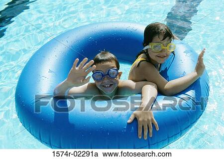 High angle view of a boy and a girl in an inflatable ring in a swimming pool View Large Photo Image Stock Image - High angle view of a boy and a girl in an inflatable ring in a swimming pool. Fotosearch