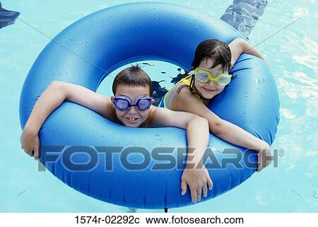 High angle view of a boy and a girl in an inflatable ring in a swimming pool View Large Photo Image Stock Image - High angle view of a boy and a girl in an inflatable ring in a swimming pool. Fotosearch