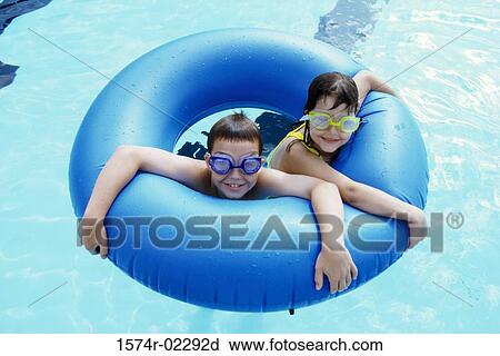 High angle view of a boy and a girl in an inflatable ring in a swimming pool View Large Photo Image Stock Image - High angle view of a boy and a girl in an inflatable ring in a swimming pool. Fotosearch