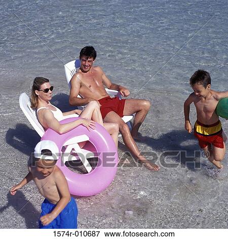 High angle view of a father and mother with their two sons at the beach View Large Photo Image Stock Photo - High angle view of a father and mother with their two sons at the beach. Fotosearch
